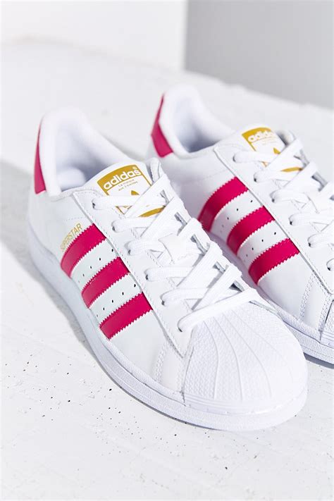 adidas shoes with pink stripes.